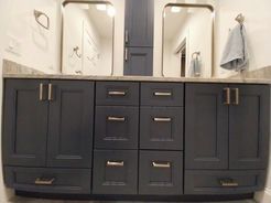 Blue bathroom vanity with silver hardware and mirrors.