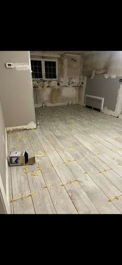 Room under renovation with new wooden-look tiles on the floor. Spacers are between tiles.