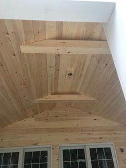 Wooden vaulted ceiling with horizontal beams, and windows at the bottom.