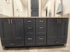 Dark blue bathroom vanity with silver hardware and a light countertop.