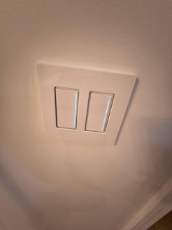 White double light switch on a white wall.
