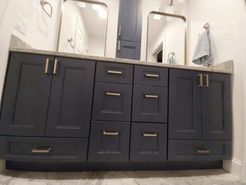 Blue bathroom vanity with silver hardware and mirrors.
