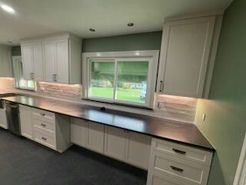 Kitchen with light gray cabinets, black countertop, and green wall.
