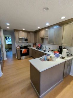 Kitchen with light wood cabinets, stainless steel appliances, and a white countertop.