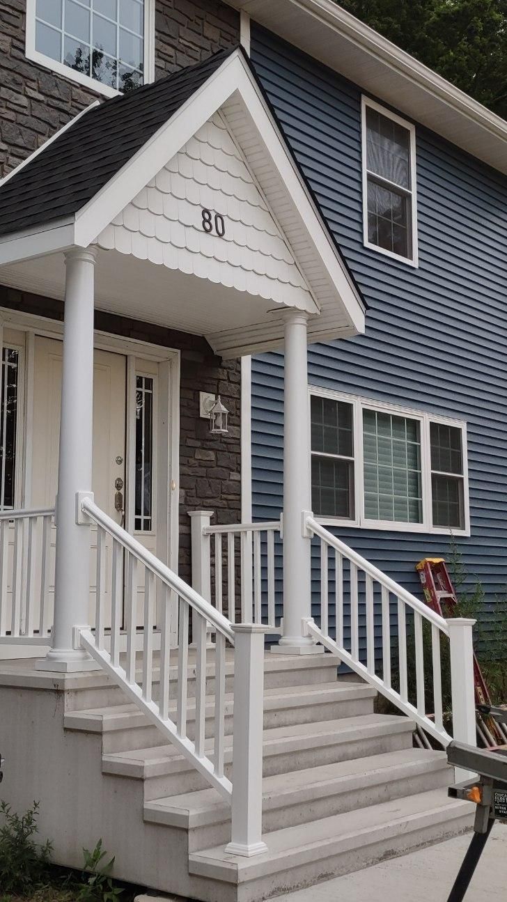 House exterior with porch, steps, and blue siding. White pillars and railing. The number 815 is visible.