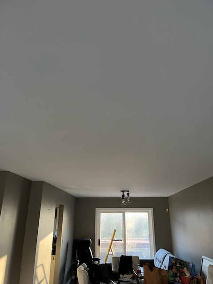 Interior of a room with gray walls, white ceiling, and a sliding glass door.