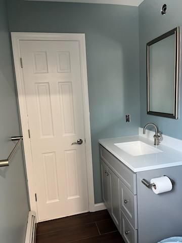 Bathroom with blue walls, white sink, gray vanity, and white door.