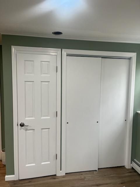 White door and sliding closet doors with white trim on a green wall.