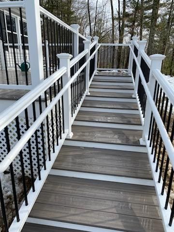 Wooden steps with white railings and black spindles lead up to a deck.