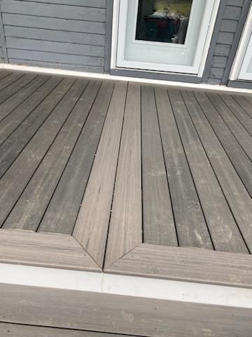 Wooden deck with a light grey border, leading to a door.
