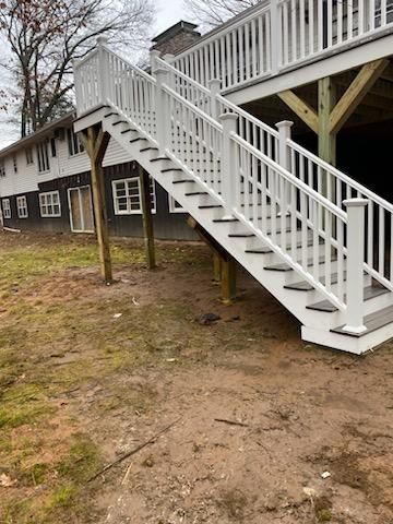 White deck stairs leading down from a white-railed deck, exterior setting.