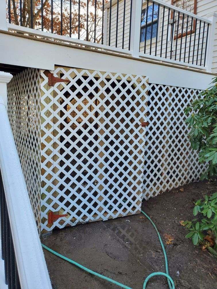 White lattice siding covers the space under a deck, supported by wooden beams.