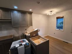 Kitchen with upper cabinets, unfinished lower cabinets, and a window.