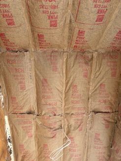 Pink fiberglass insulation installed between ceiling joists, labeled R38.