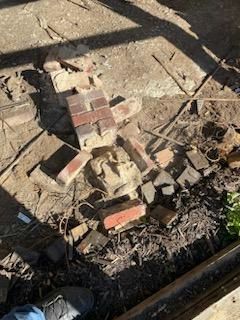 Bricks and debris scattered on a dirt floor, possibly from demolition.