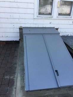 Gray basement door outside a white house.