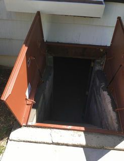 Brown basement doors open, leading into a dark concrete entrance.