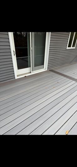 Exterior of a house with a gray deck and sliding glass door.