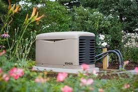 Tan Kohler home generator in a garden setting, surrounded by flowers and greenery.