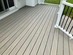 Gray composite deck with black railing and white supports.