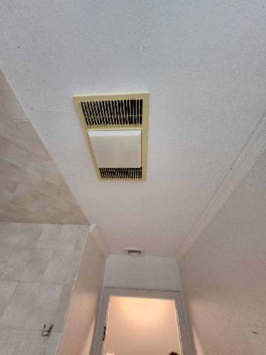 Bathroom ceiling with vent and light fixture above a doorway.