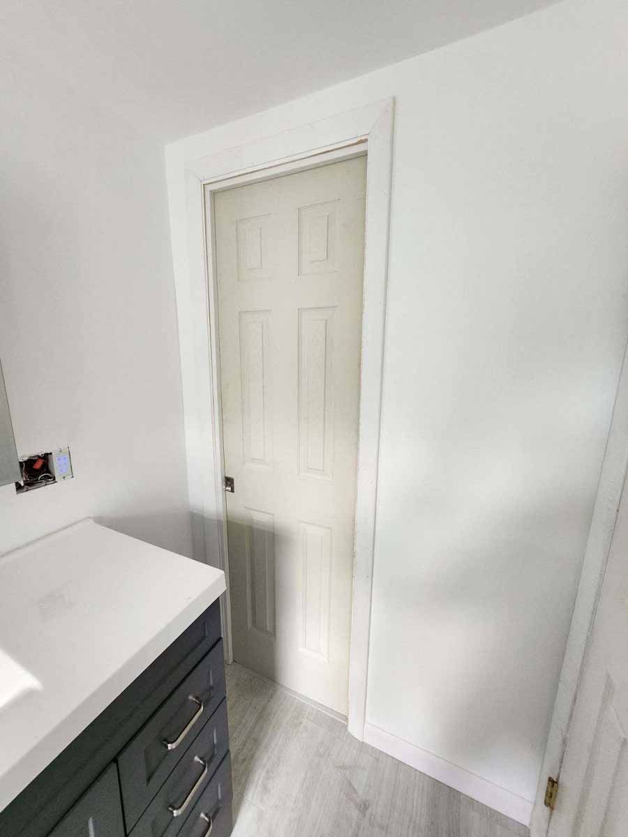 White door in a bathroom with a gray vanity.