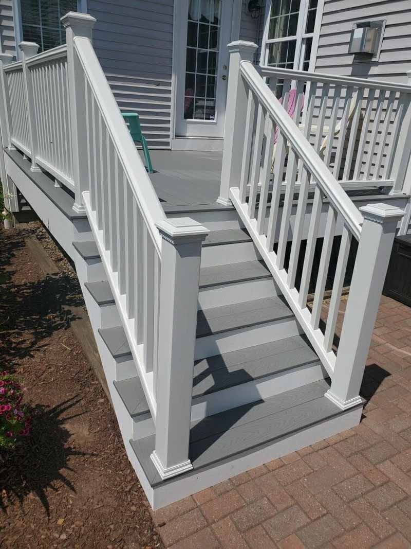 Gray deck with white railing and steps.