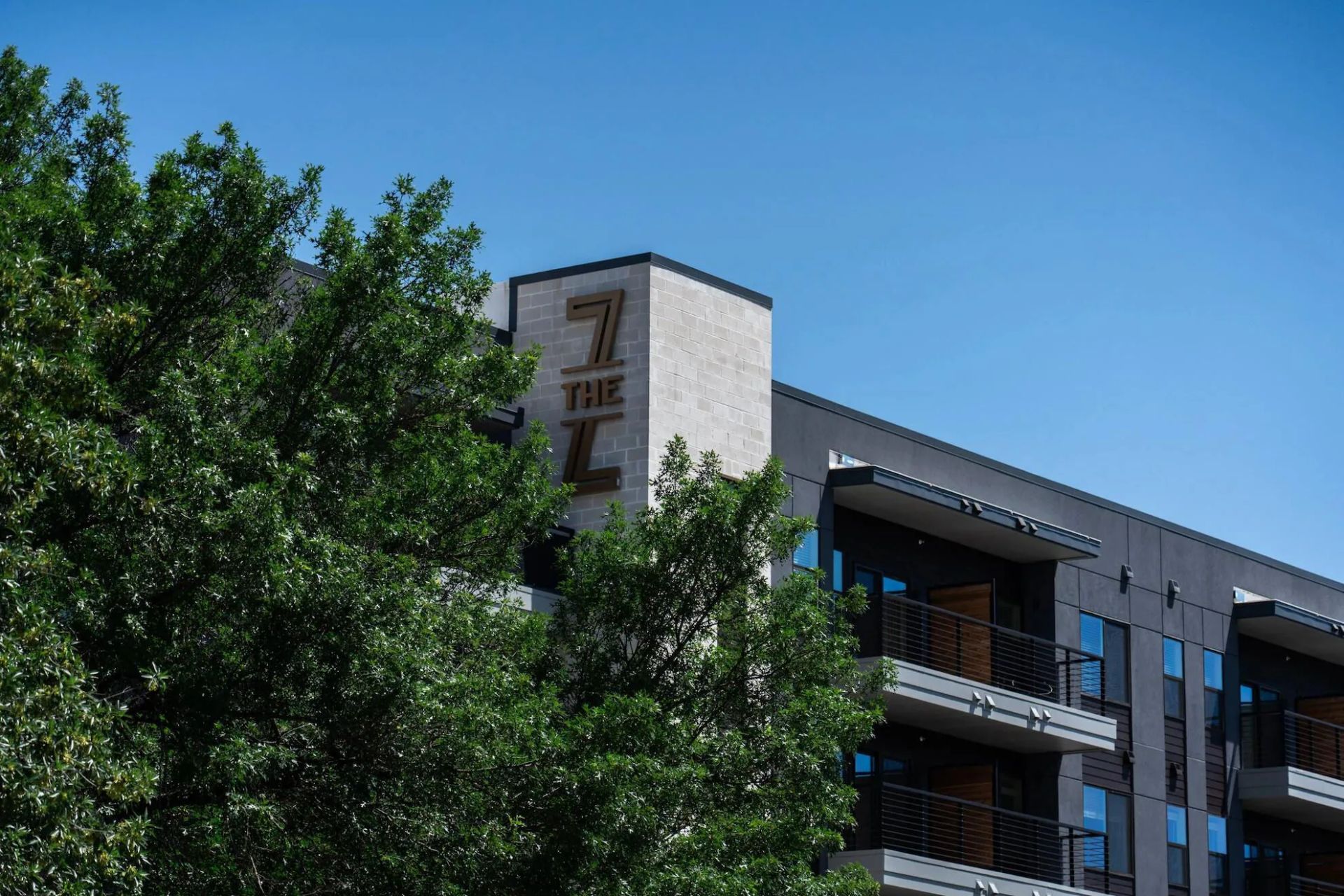 Apartment building with a tan facade and a sign that reads 
