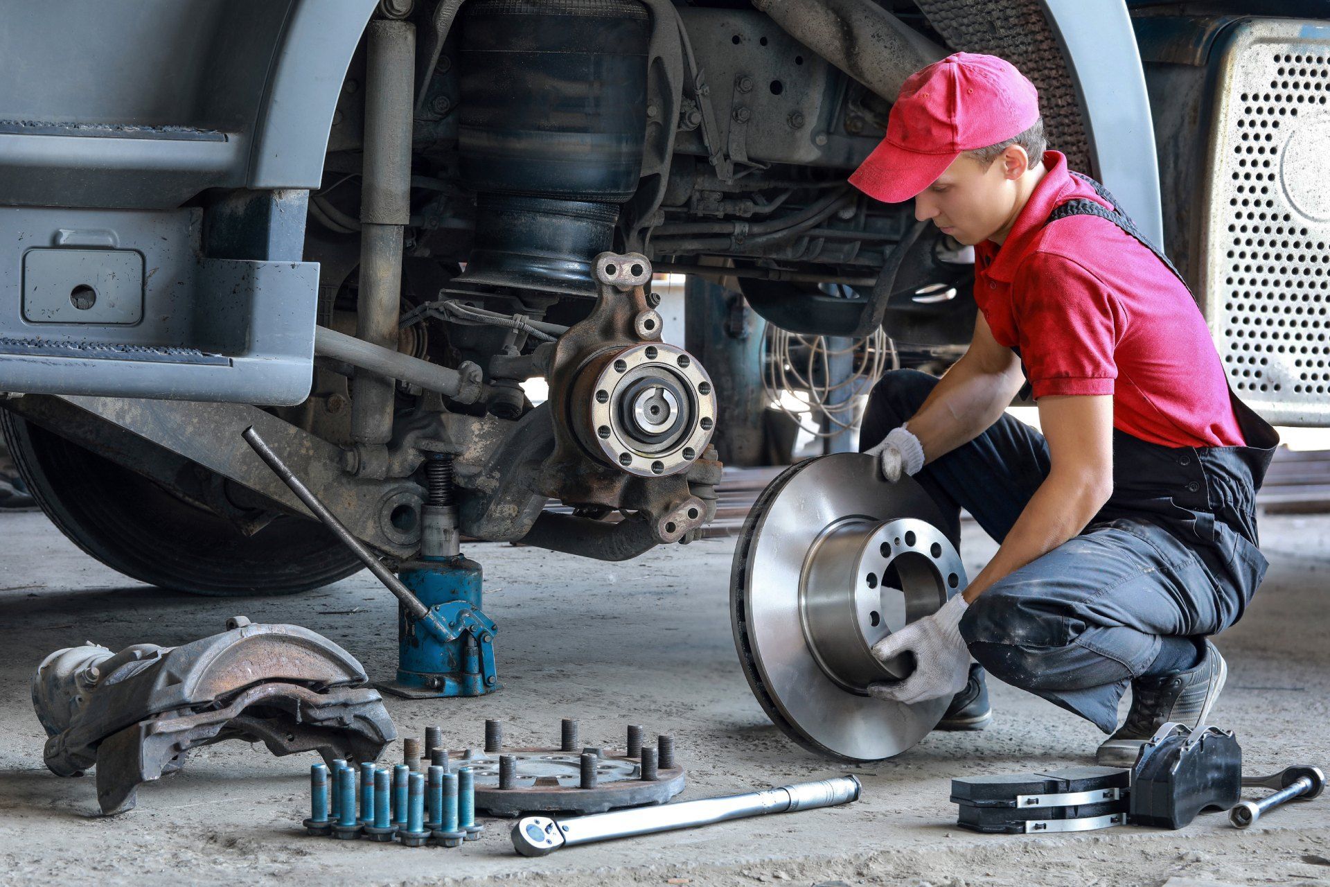 A man is working on a truck in a garage.