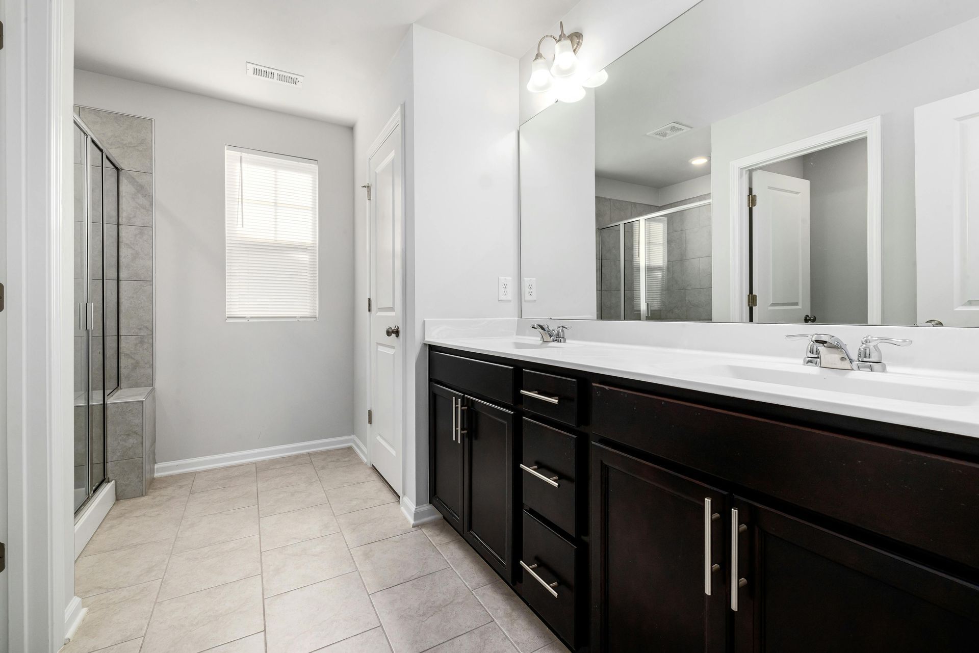 A bathroom with two sinks and a large mirror.