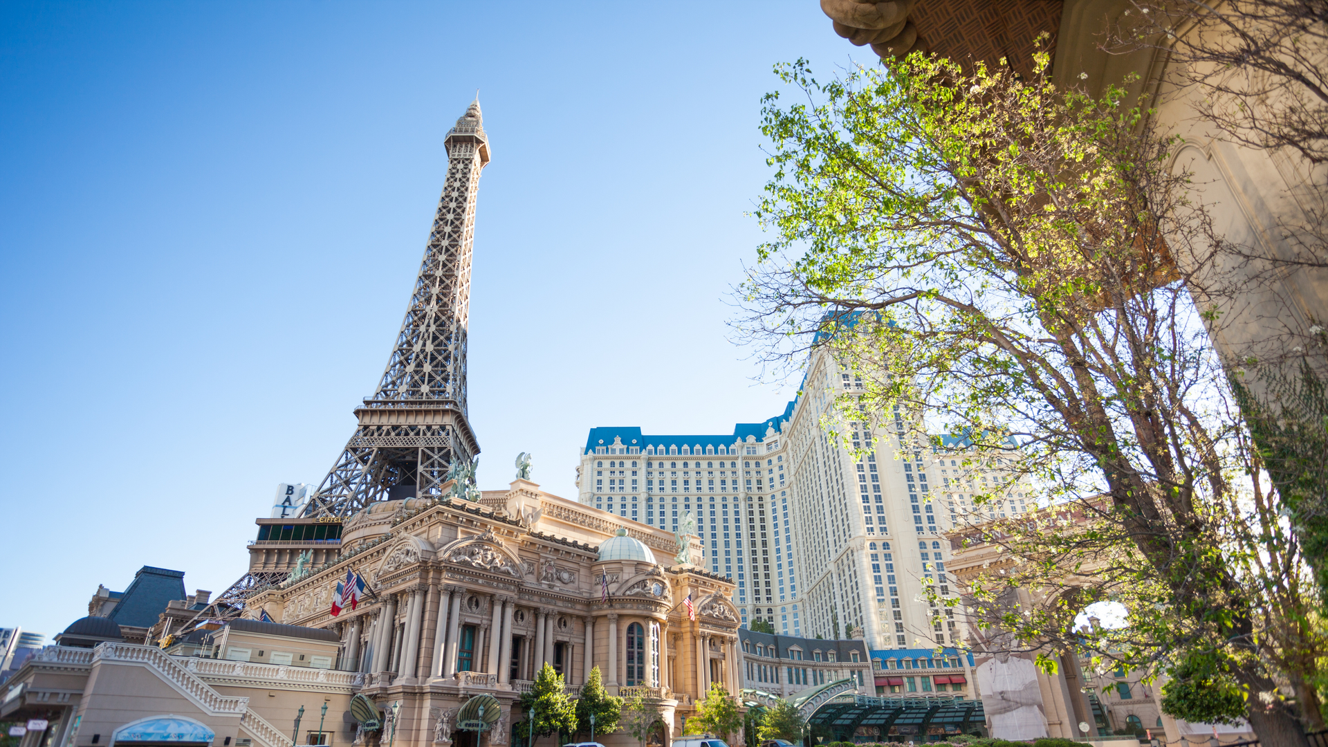 The eiffel tower is surrounded by buildings and trees in las vegas.