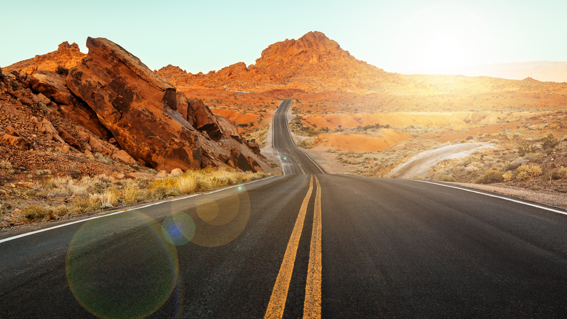 A road in the desert with mountains in the background