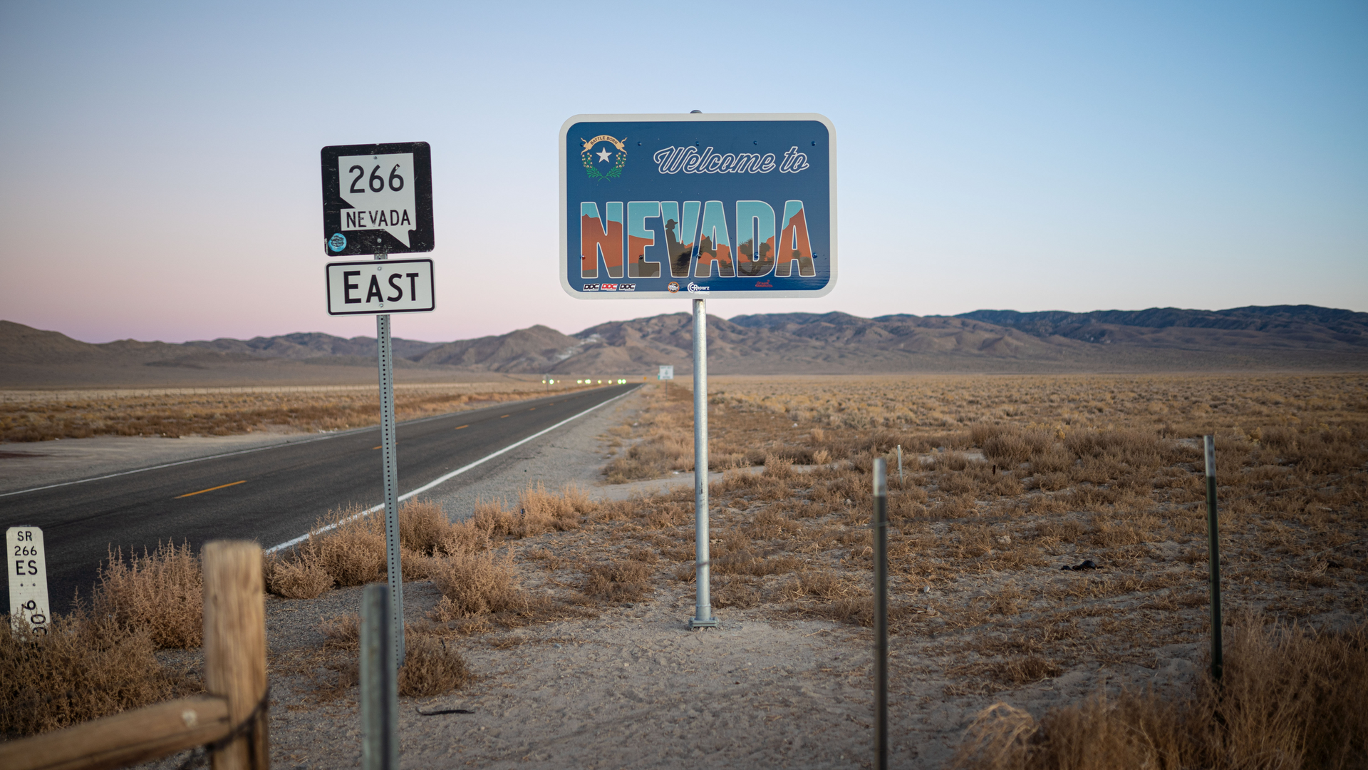 A sign on the side of a road that says welcome to nevada