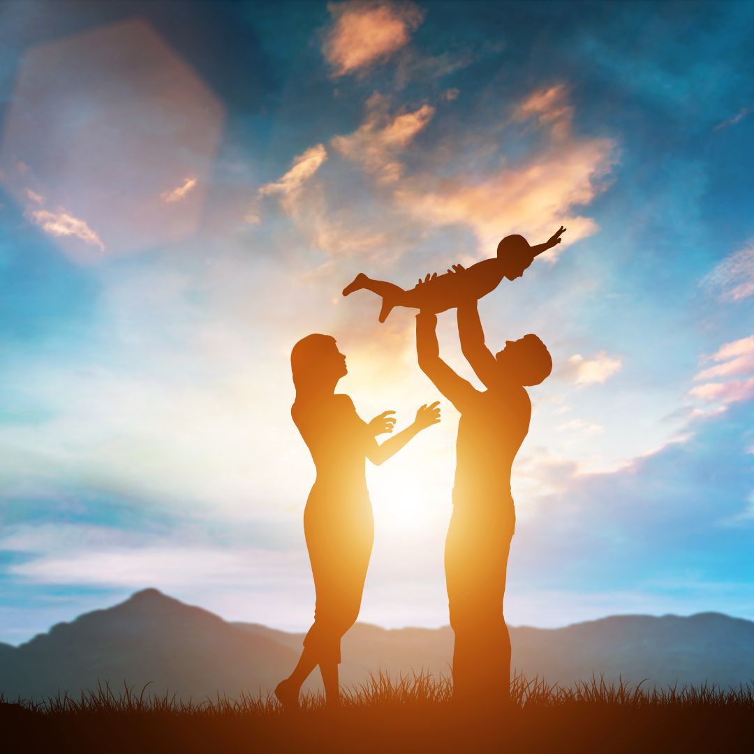 A man and woman are holding a child in the air.