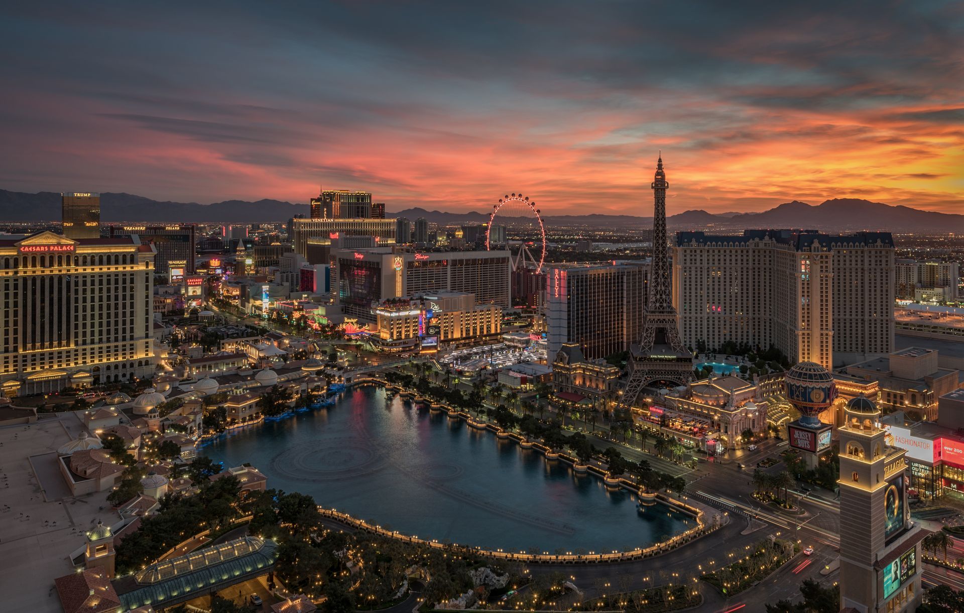 An aerial view of las vegas at sunset with a lake in the middle of the city.