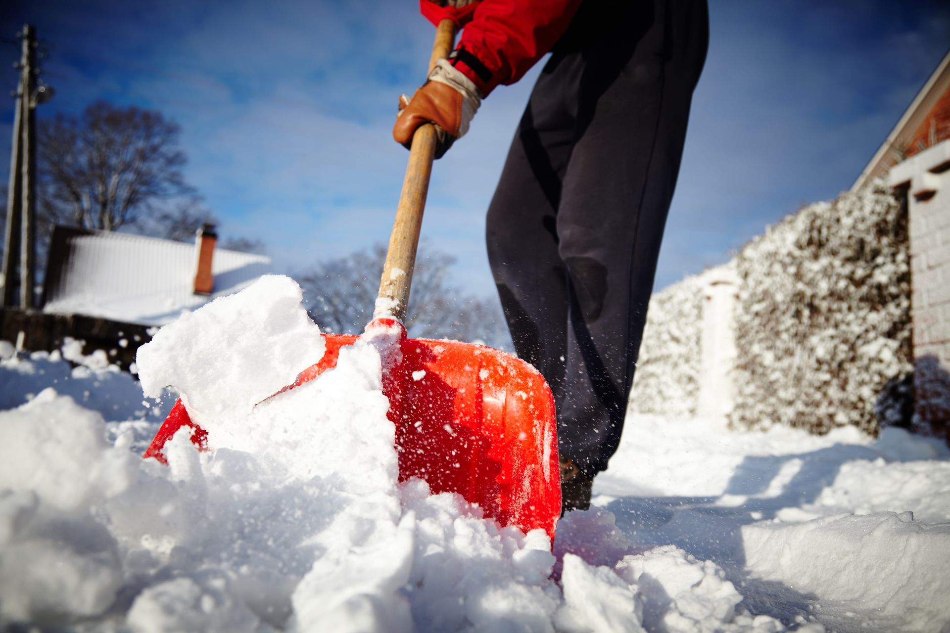 A person is shoveling snow from the ground with a shovel.