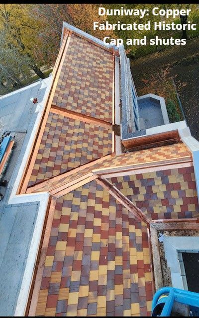 Overhead view of a roof with copper cap and chutes; multicolor shingle pattern.