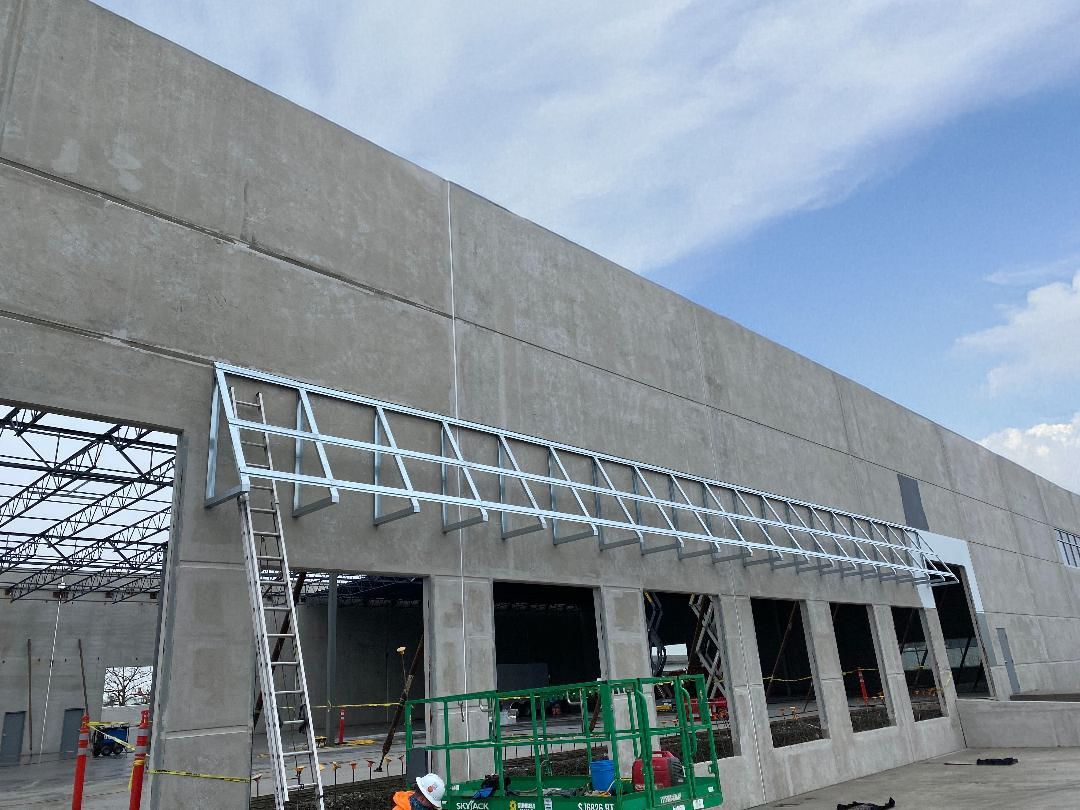 View of downtown buildings in Portland, Oregon from above; building facade in foreground, green hills in background.
