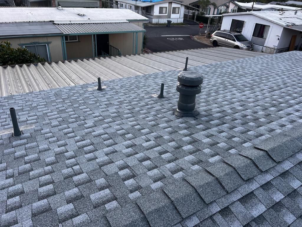 A roof with a chimney on it and a lot of shingles on it.
