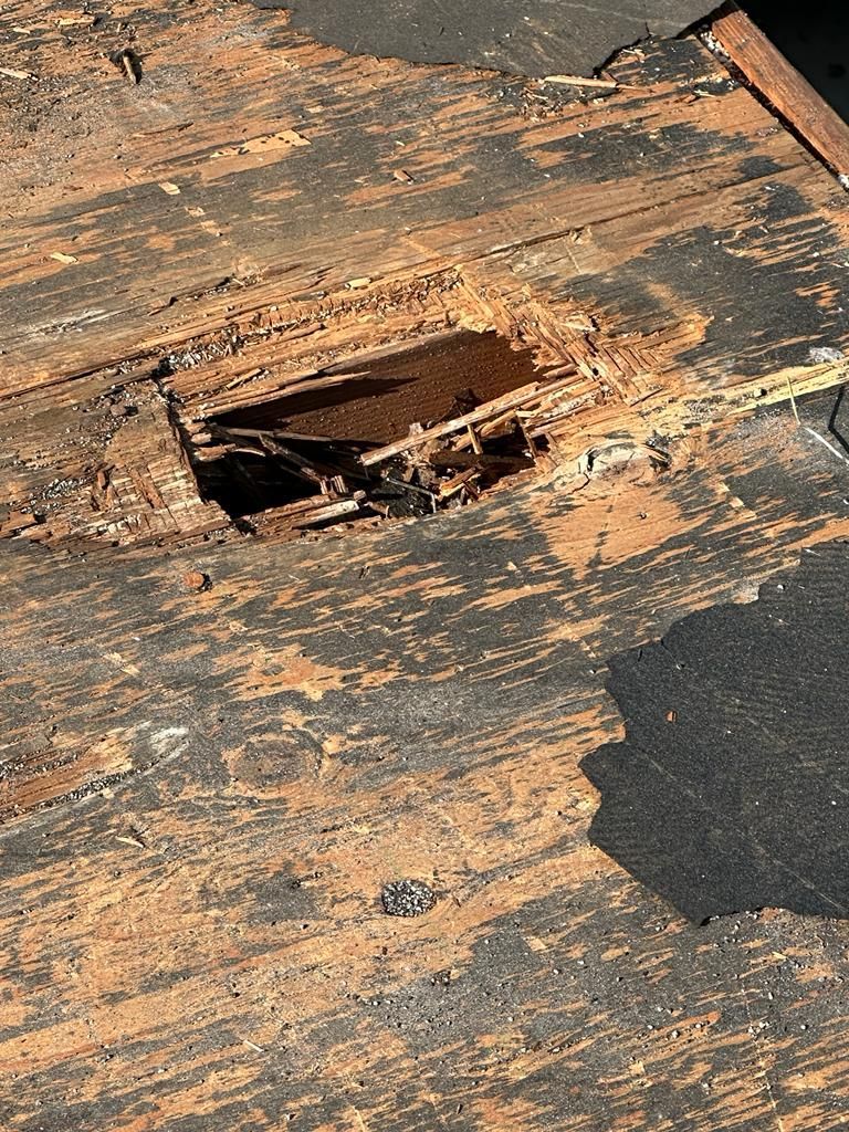 A close up of a hole in a wooden roof.