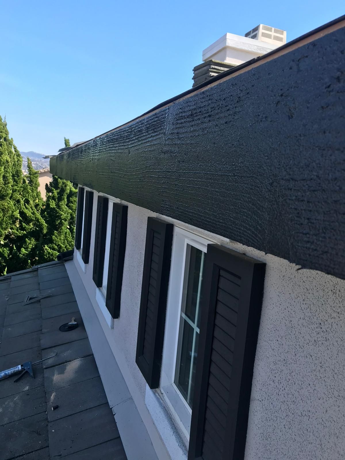 A white building with black shutters on the windows