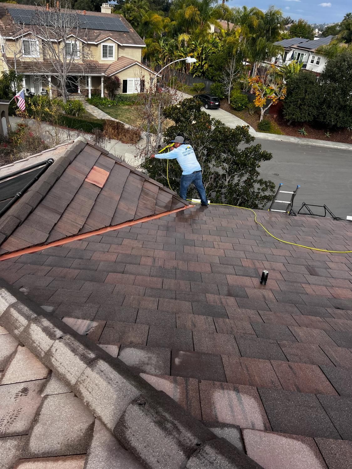 A man is working on the roof of a house.