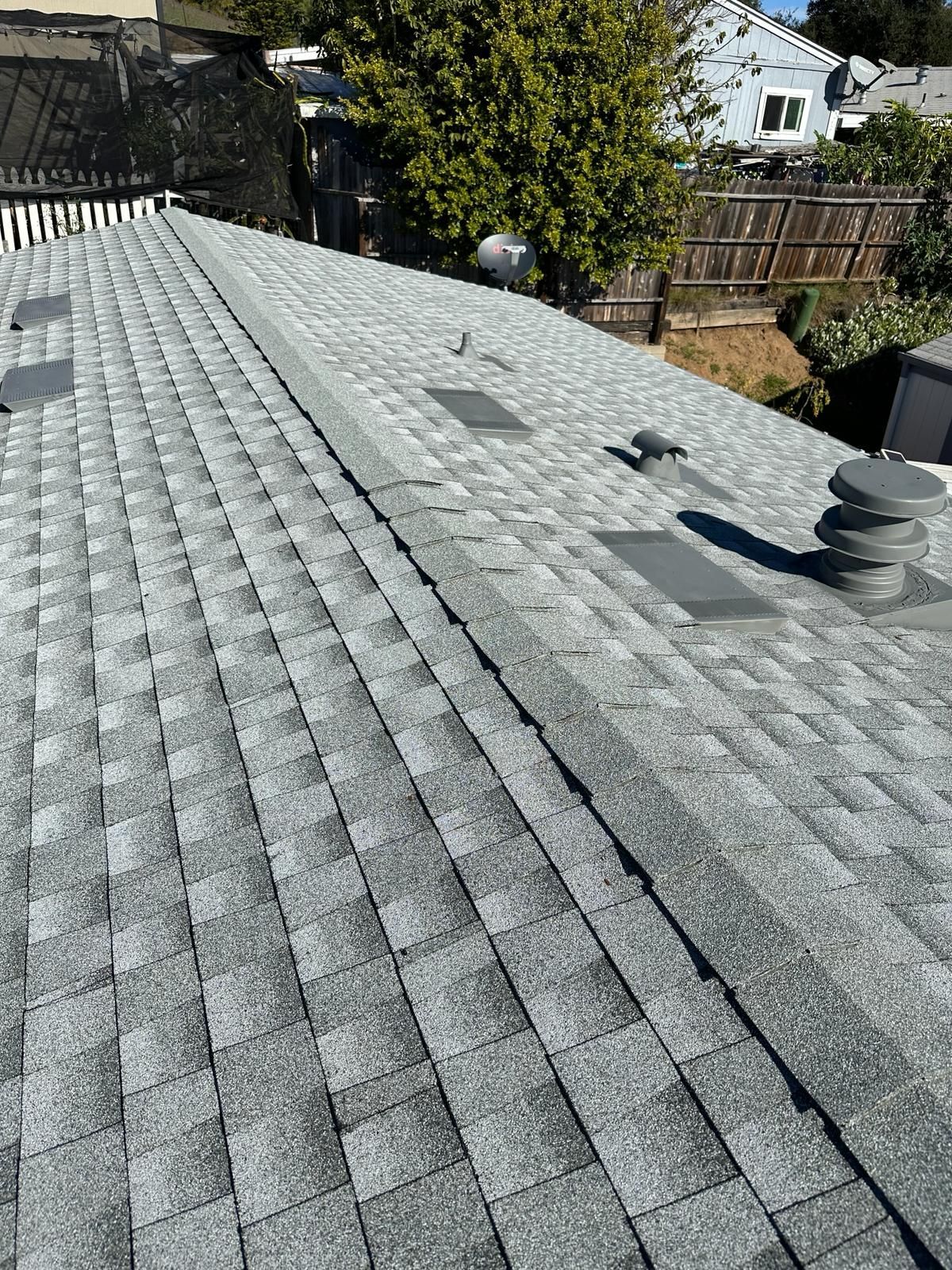 A roof with a lot of shingles and a chimney on it.
