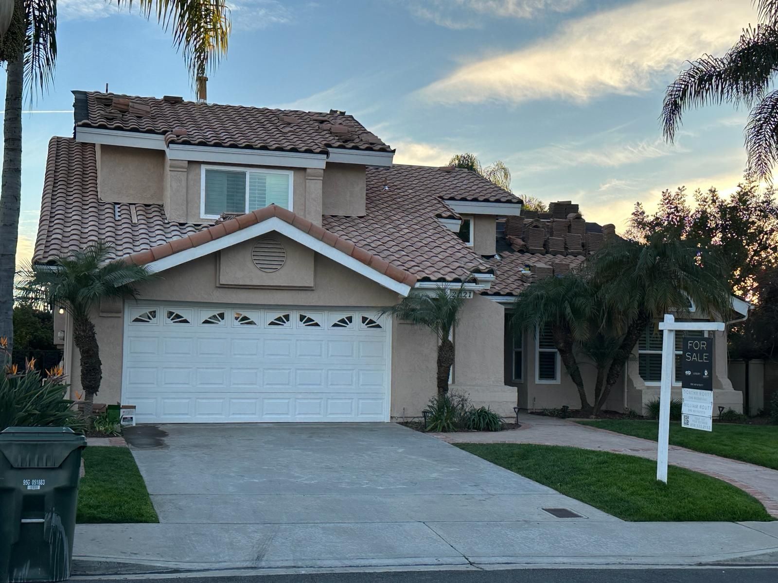 A house with a for sale sign in front of it