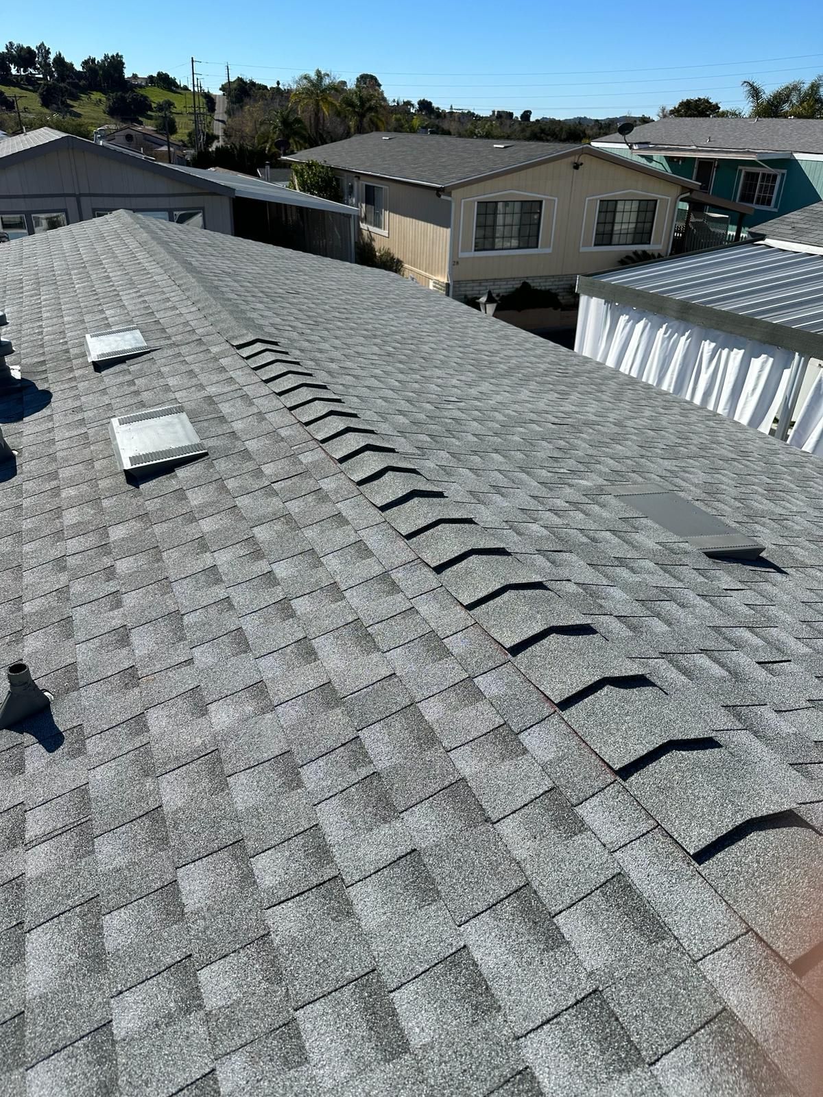 The roof of a house with a row of skylights on it.