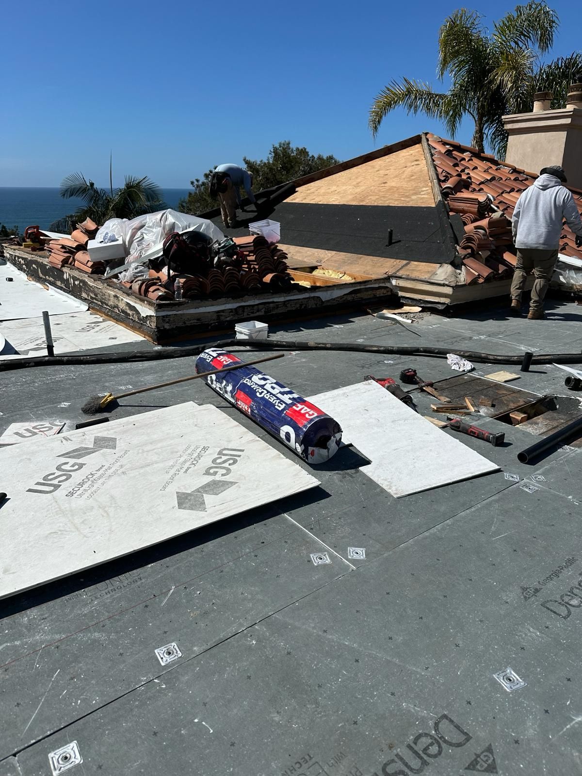 A man is working on the roof of a house.