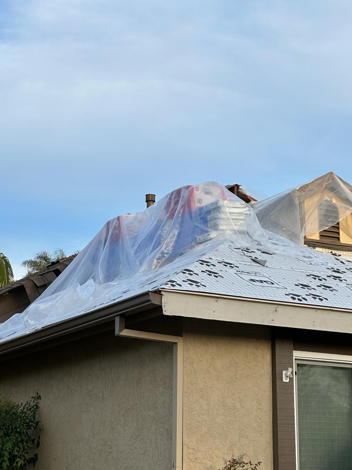 The roof of a house is covered in plastic.