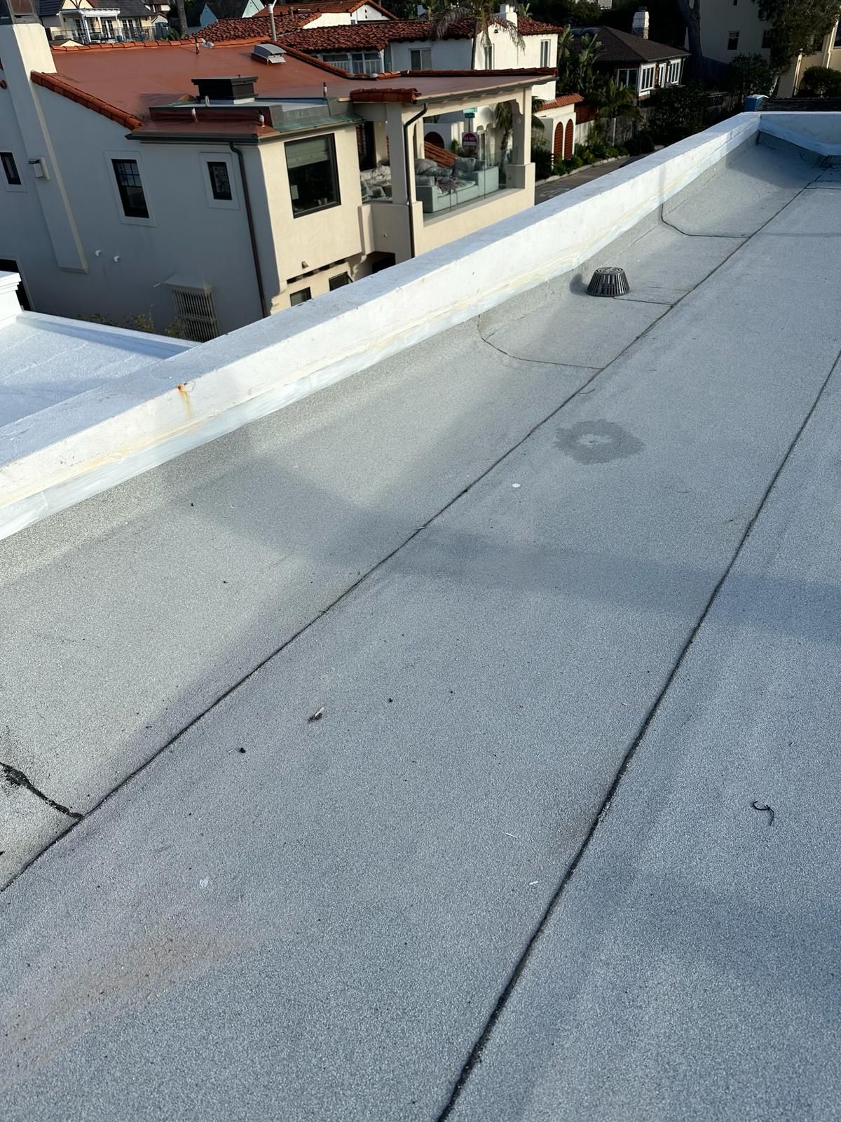 A close up of a roof with a few buildings in the background.