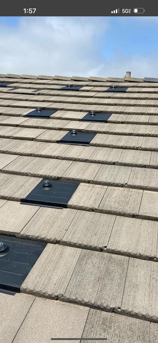 A roof with a lot of tiles and solar panels on it.