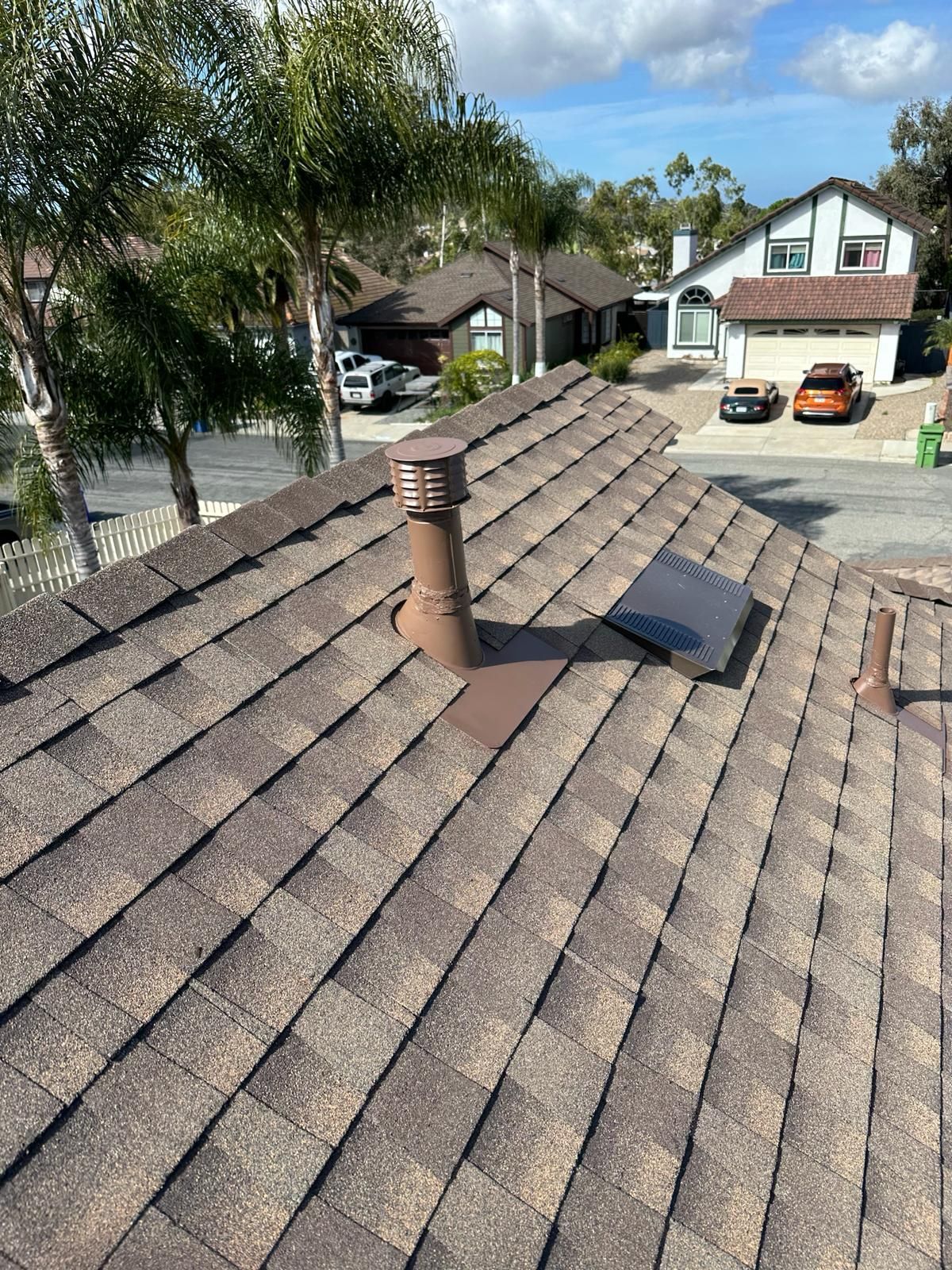 A roof with a chimney on it in a residential area.